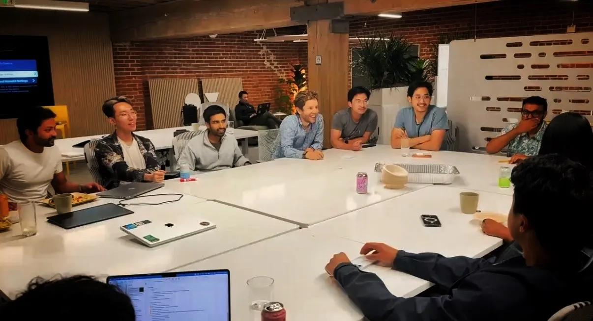 The cohort in discussion around a table at the Outcast office
