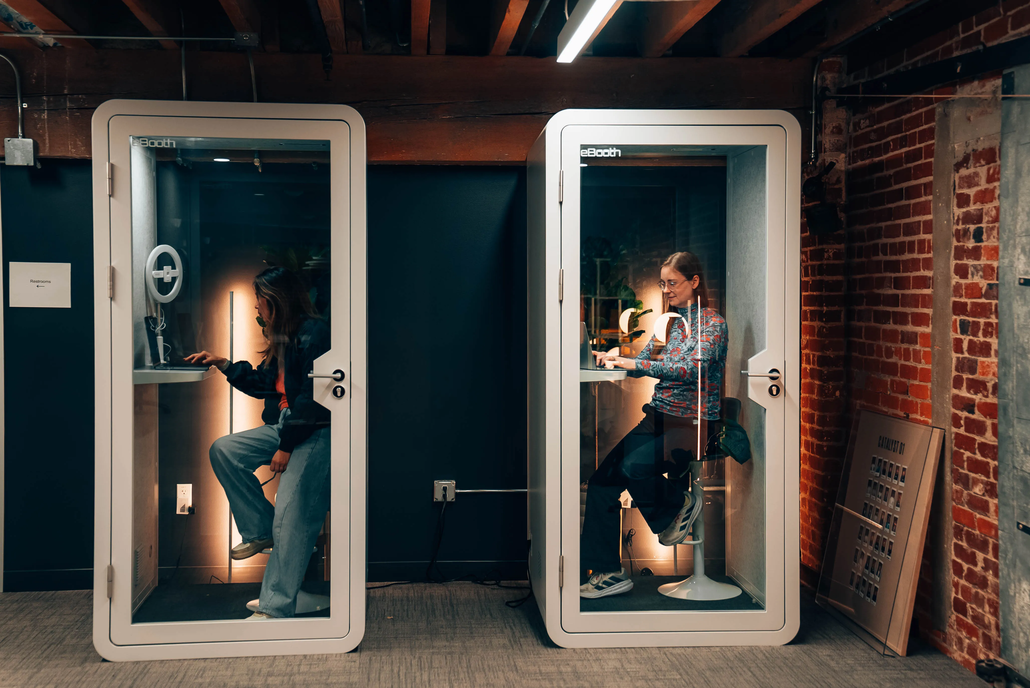 Founders working in the phone booths at the Outcast office